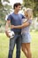 Young Couple Holding Soccer Ball In Countryside