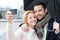 Young couple on holidays under the rain taking selfie