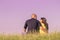 Young couple hugging back rear view low angle sky grass