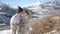 Young couple hugging and kissing with beautiful snowy mountains on background.