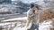 Young couple hugging and kissing with beautiful snowy mountains on background.
