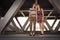 Young couple hugging in the summer daylight on a bridge construction in the city outdoors. copy space