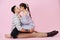 Young couple hugs and kissing on a pink background