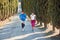 Young couple jogging uphill on a gravel road with trees and a car following them. professional, personal, trainer