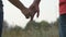 Young couple joining hands outdoor. Man and woman taking arms on nature background. Male and female hands comforting and