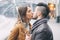 Young couple kissing under umbrella in rainy day in the city center - Romantic lovers having a tender moment outdoor