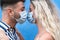 Young couple kissing while wearing face surgical mask during corona virus outbreak