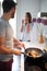 Young couple in kitchen talking, smiling,  while cooking and drinking coffee. lifestyle, modern living concept