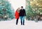 young couple laughing having fun while walking in snowy winter park