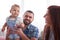 Young couple with liitle daughter relaxing on couch