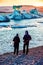 Young couple looking at beautiful landscape with depths of ice in the famous Jokulsarlon glacial lagoon in Iceland. Exotic