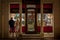 Young couple looking at a jewelry store window at night in Szeged, to purchase luxury jewels.