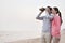 Young Couple Looking at the Ocean with Binoculars