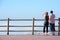 Young couple looking out to sea from high viewpoint