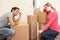 Young couple looking upset among boxes