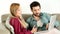 Young couple lounging on couch with laptop at home