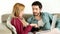 Young couple lounging on couch with laptop at home