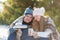 Young couple in love drink a hot drink from a thermos, sitting in the winter in the forest, tucked into warm, comfortable rugs,