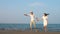 Young couple in love enjoying romance in elegant clothing on beach slow motion.