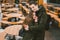 A young couple in love and a girl and a student stand embracing near the tables of a street terrace cafe closed empty without