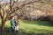 Young couple in love having a date under pink blossom trees.