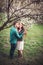 Young couple in love having a date under pink blossom trees.