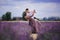 Young couple in love hugging and dancing in a lavender field on summer. girl in a luxurious purple dress