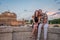 Young couple in love, husband and wife, on the stone bridge of the Tiber River embankment, against the backdrop of the Angel Vatic