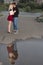 Young couple in love kissing reflected in puddle