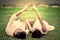Young couple in love laying down in grass and making hand in heart