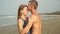 Young couple in love man and woman kiss and hug on the background of the sea.