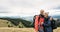 Young couple in love man and woman tourists stand on the top of the mountain and smile. tourists in the mountains during