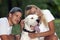 The young couple in love relaxes in nature with their dog