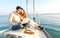 Young couple in love on sail boat having fun remote working at laptop- Happy luxury lifestyle on yacht sailboat