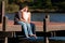 Young Couple In Love Sit Barefoot On Dock