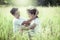 Young couple in love sitting and look each other in the meadow