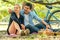Young couple in love sitting on mat  and pointing finger on picnic in the park. dating, romance outdoors