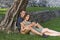 Young Couple in Love sitting under a tree in a castle