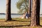 Young couple in love sitting under tree in the Park, enjoying a beautiful summer day at sunset.