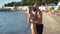 Young couple in love stand on the beach while on vacation and kiss passionately on the ocean shore. Spouses or lovers