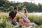 Young couple in love on summer picnic with watermelon. Loving couple sitting by the river, talking, smiling, laughing