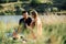 Young couple in love on summer picnic with watermelon. Loving couple sitting by the river, talking, smiling, laughing