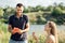 Young couple in love on summer picnic with watermelon. Loving couple sitting by the river, talking, smiling, laughing