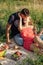 Young couple in love on summer picnic with watermelon. Loving couple sitting by the river, talking, smiling, laughing