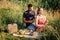 Young couple in love on summer picnic with watermelon. Loving couple sitting by the river, talking, smiling, laughing