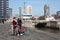 Young couple in love with tourists traveling in rotterdam with their bicycles on an autumn day. visiting the port and the river in