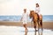 Young couple in love walking with the horse at sea beach on blue sky . honeymoon tropical sea summer vacation. bride groom on the