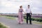 Young couple in love walking near a lavender field on summer cloudy day. girl in a luxurious purple dress and with hairstyle with