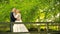 Young couple in love walking on suspended wooden bridge in the forest