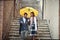 A young couple in love which is talking while descending the stairs in the city during a rainy day. Walk, rain, city, relationship